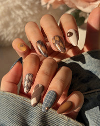 Luxury press on nails in deep blue, brown, and caramel tones with plaid patterns and almond shape, showcasing a refined, heritage-inspired design