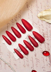 Matte velvet red press on nails in an elegant almond shape, displayed in a luxury flat lay with gold accents and a refined, timeless aesthetic.