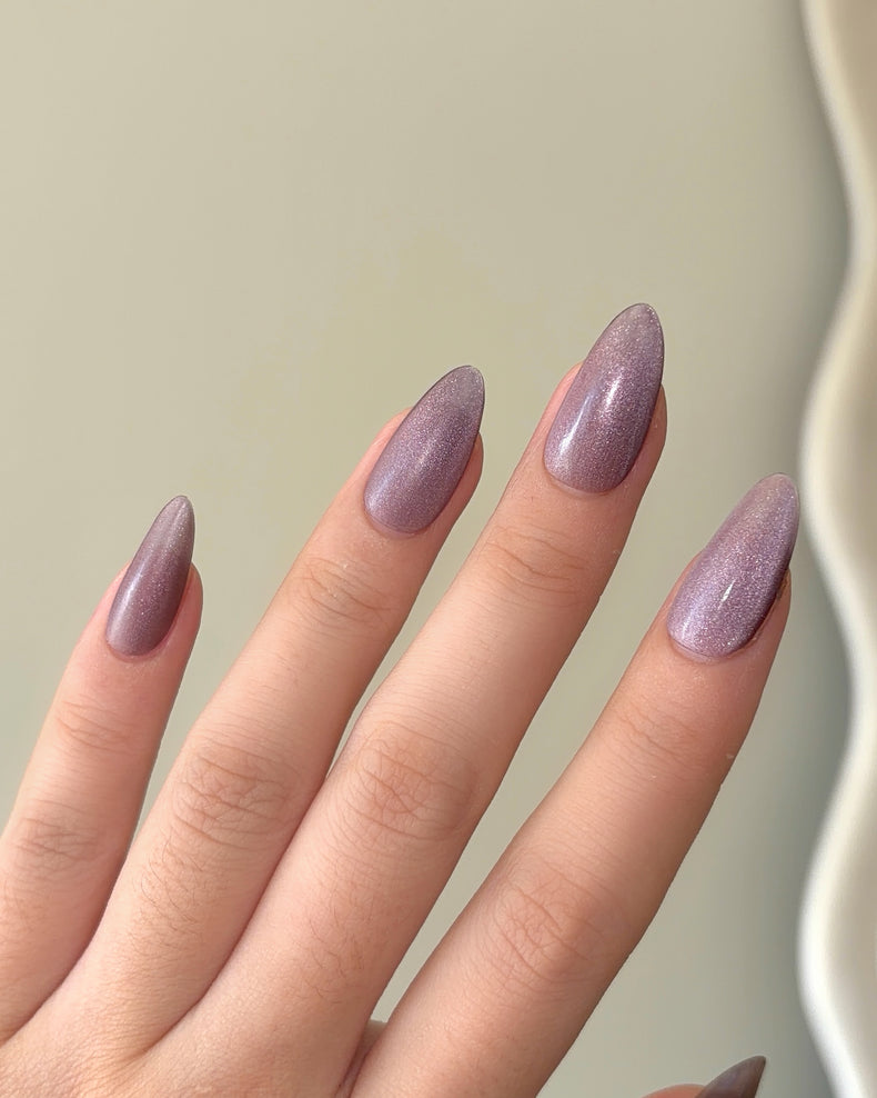 Luxury press on nails in a soft nude-violet color with a velvet finish and almond shape, presented in a refined minimal design by ZIYURA.