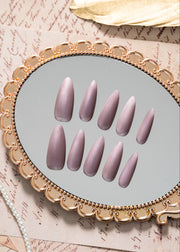 Luxury press on nails in a soft nude-violet color with a velvet finish and almond shape, presented in a refined minimal design by ZIYURA.